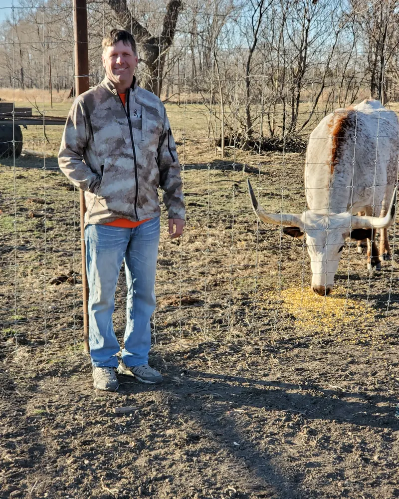 Carl Hanson with a longhorn on the farm